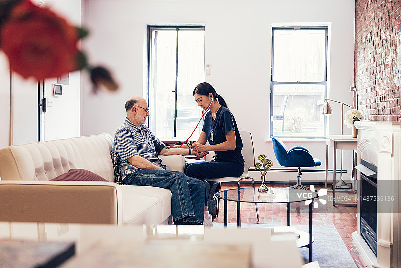 护士在家为老年男性测量血压 - 家庭健康护理检查图片素材