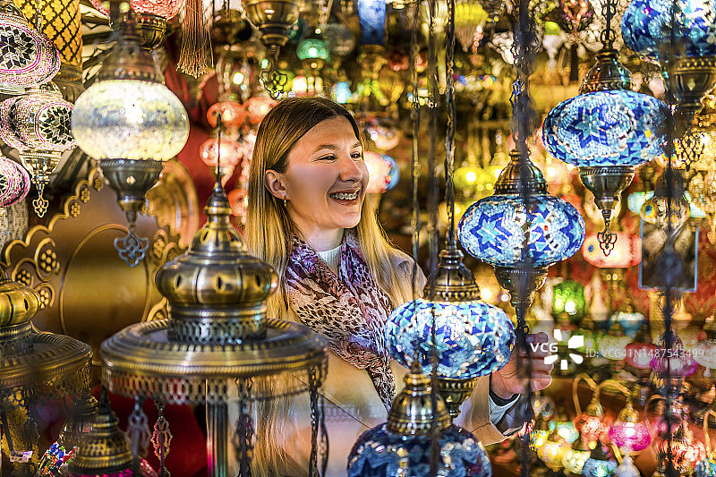 女人在伊斯坦布尔大巴扎挑选灯具图片素材