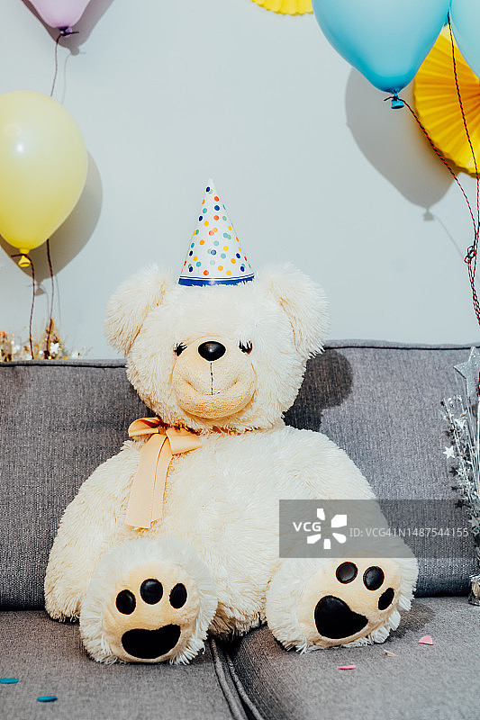 生日聚会：戴派对帽的泰迪熊与气球图片素材