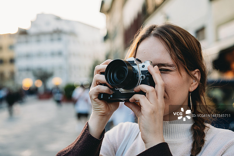 女子在日落时拍摄城市图片素材