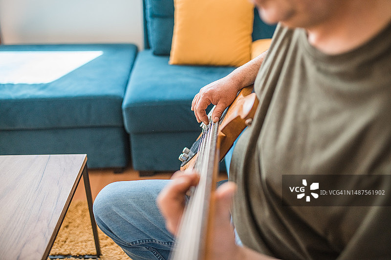 男吉他手在家弹贝斯特写图片素材