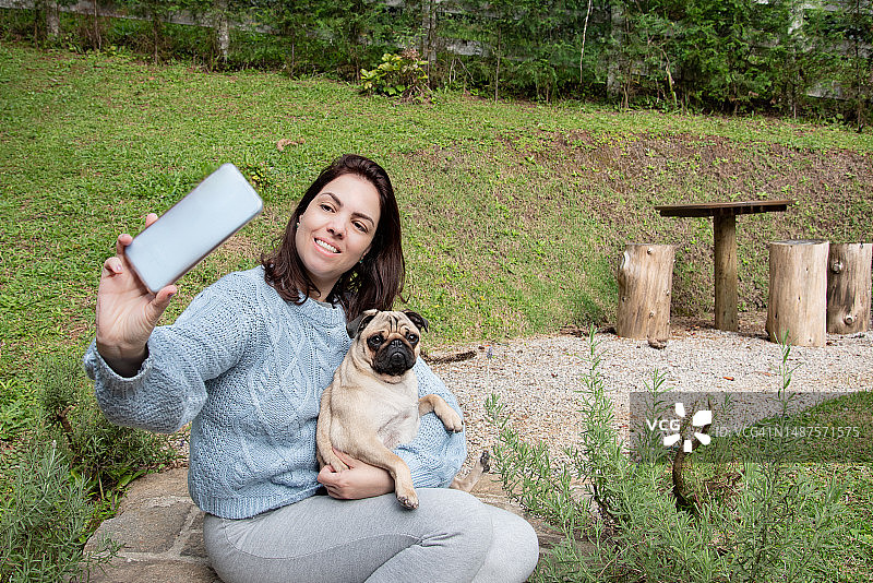 女人在户外与巴哥犬自拍图片素材