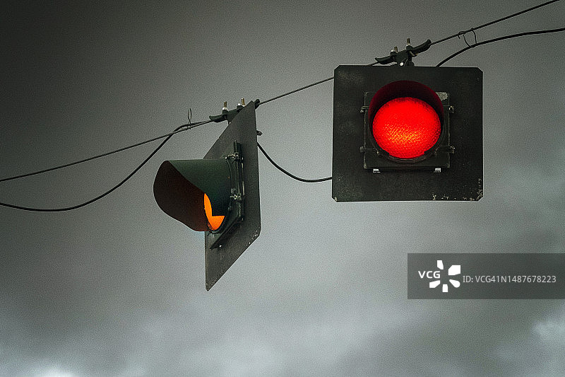 日落时悬挂的红色交通信号灯图片素材