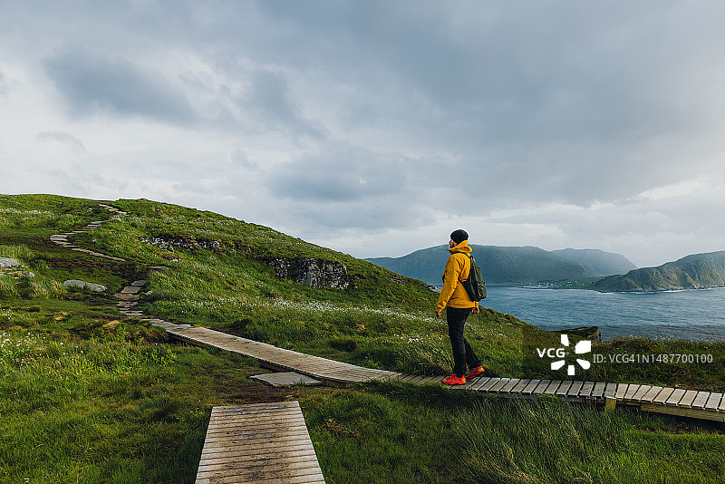 背包客在挪威Runde岛的风景小径上徒步旅行图片素材