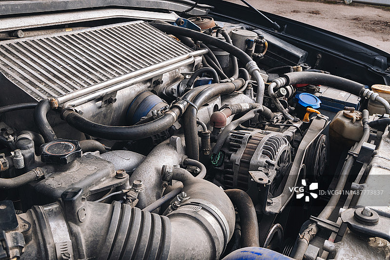 引擎盖下汽车发动机布满灰尘的细节图片素材