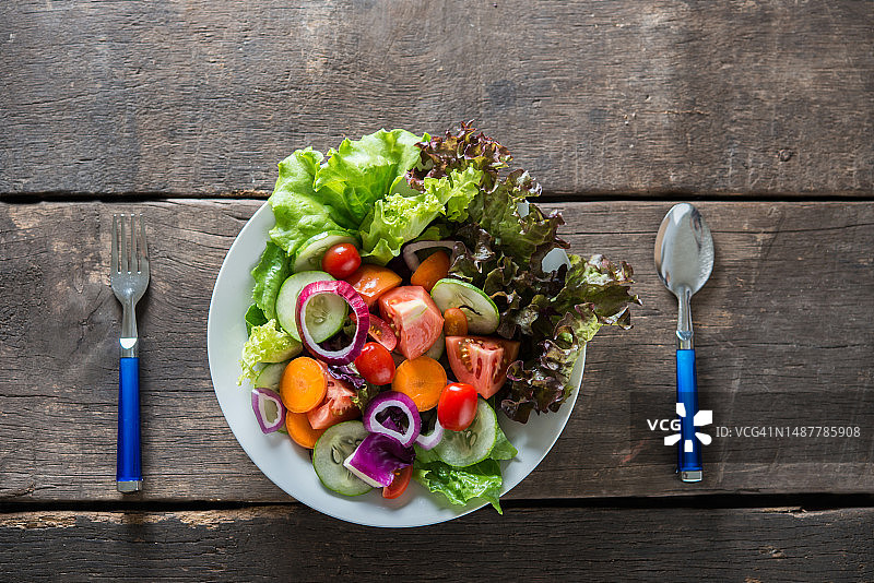 木质背景上的新鲜蔬菜沙拉顶视图，罗马尼亚图片素材