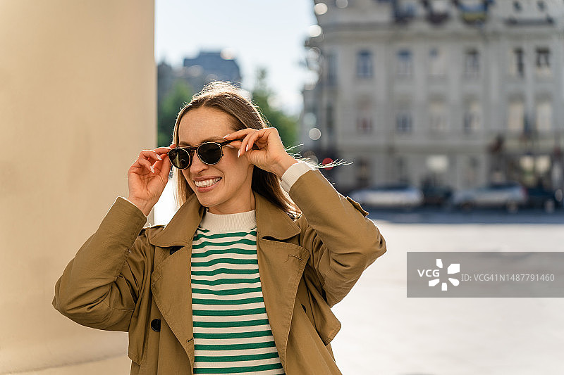 笑容满面的女人在立陶宛城市户外戴太阳镜图片素材