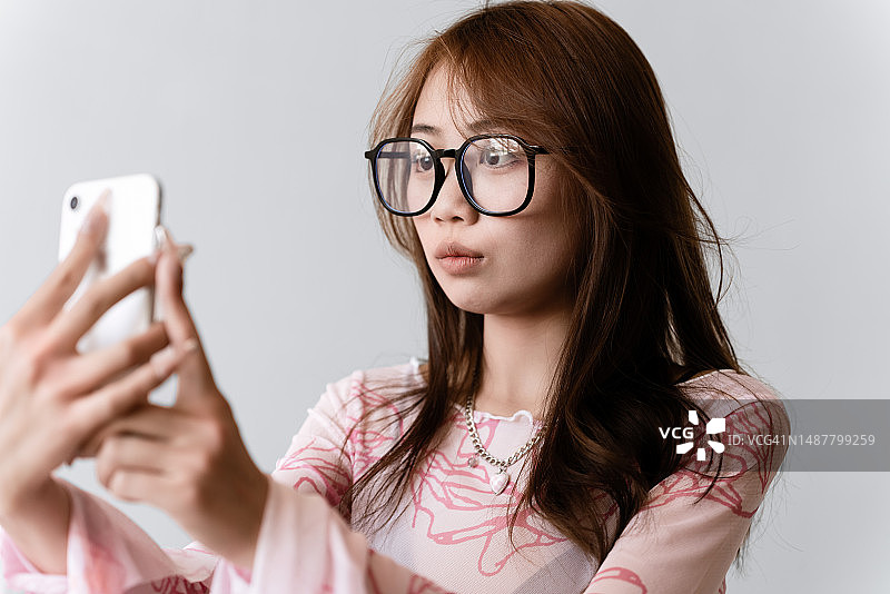 年轻女子用手机自拍的肖像图片素材