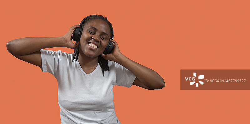非洲年轻女子戴耳机灿烂笑容图片素材