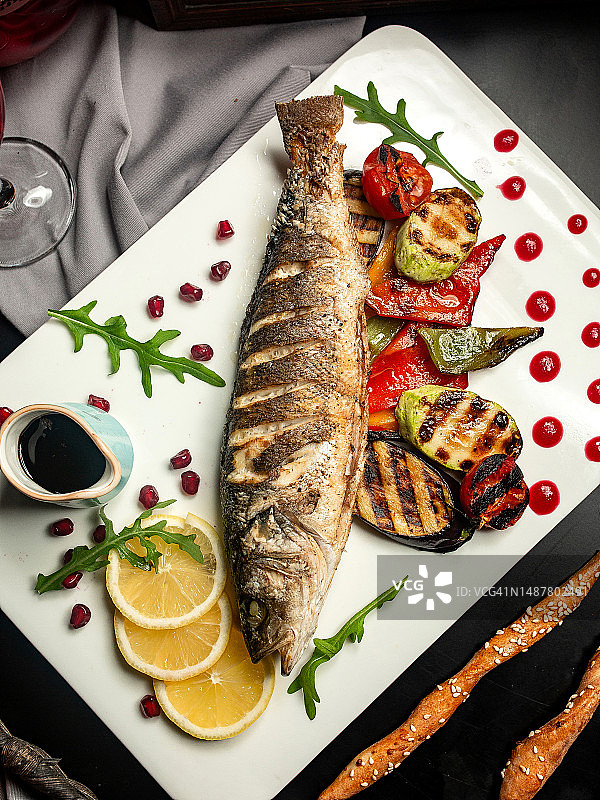 烤鳟鱼配茄子、西葫芦、甜椒和石榴酱顶视图图片素材