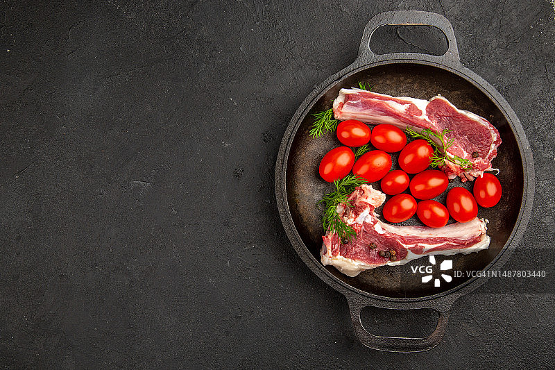 平底锅内肉片与红色番茄顶视图图片素材