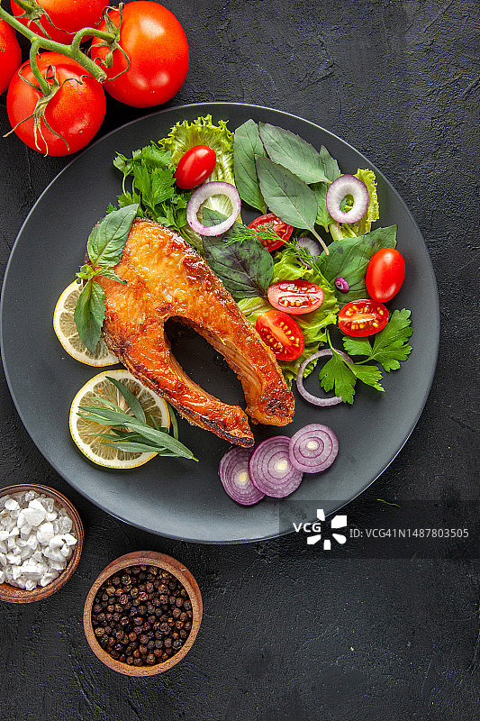 深色背景上的美味鱼和新鲜蔬菜图片素材