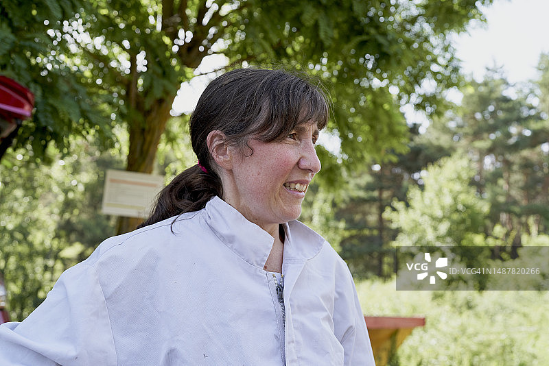 穿着养蜂人服装的女人，背景是树林图片素材