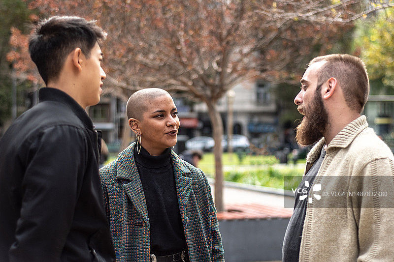 年轻朋友/同事在户外会面交谈图片素材