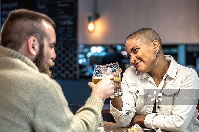 情侣在酒吧/餐厅约会时举杯庆祝图片素材