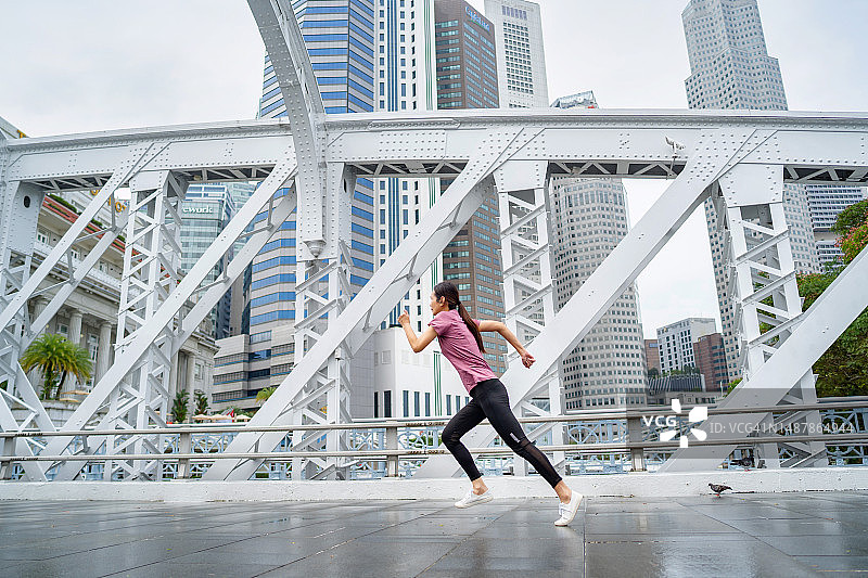 在城市中短跑的女运动员图片素材