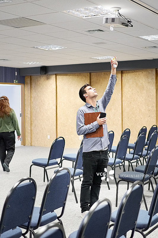 年轻男人在会议活动后关闭投影仪图片素材