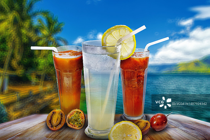 三种不同鲜榨果汁：百香果、柠檬和 tamarilo 果汁，背景是美丽的托巴湖图片素材