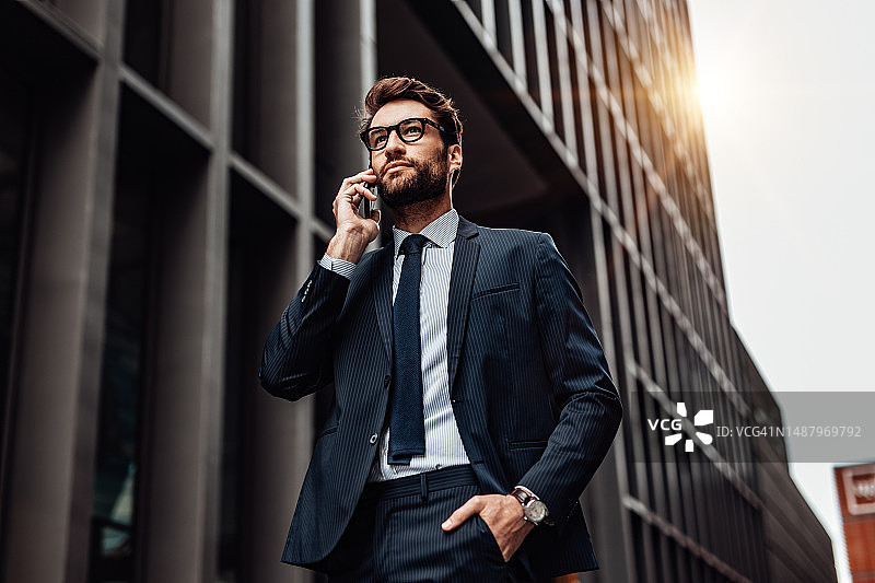 在城市中使用智能手机的积极男士肖像图片素材