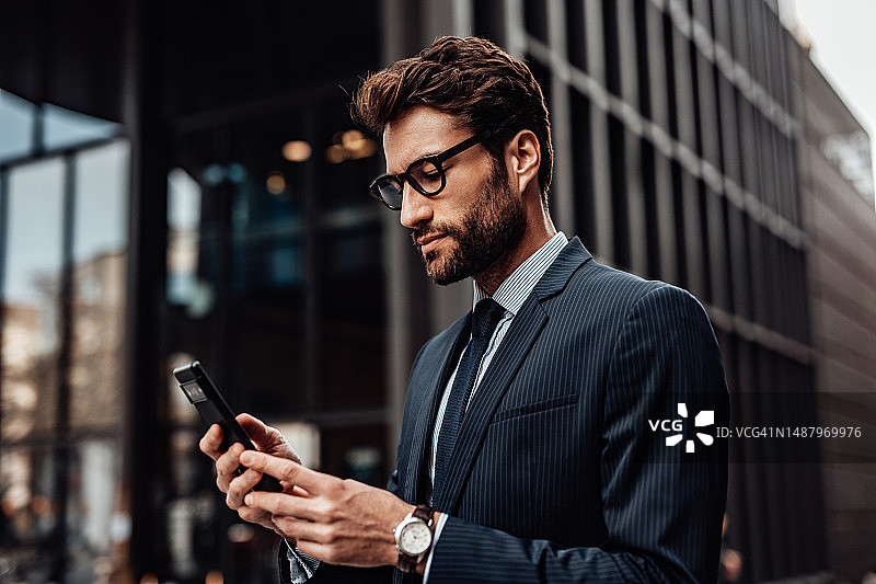 在城市中使用智能手机的积极男士肖像图片素材