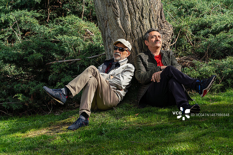 活力老年老友在公园度过美好的一天，坐着休息，思考图片素材