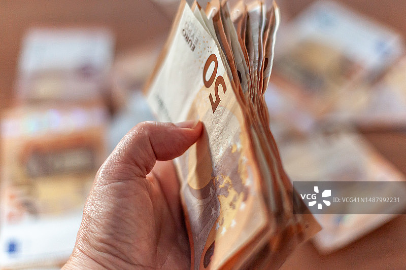 女人手中拿着一叠欧元图片素材