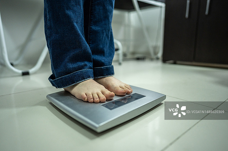特写：女子在医疗诊所使用电子秤图片素材