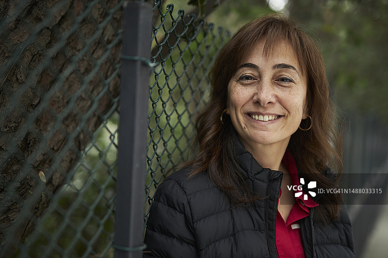 户外栅栏旁迷人的中年白人女性图片素材