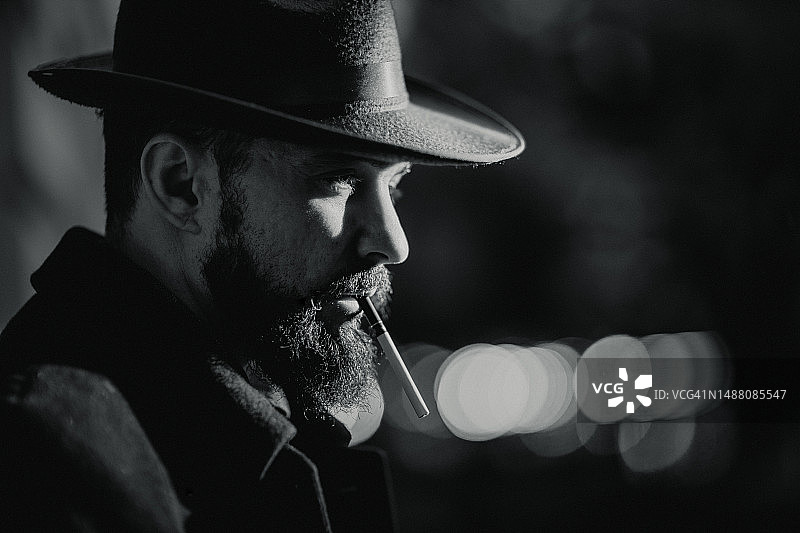 夜城中吸烟侦探的黑色风格肖像图片素材