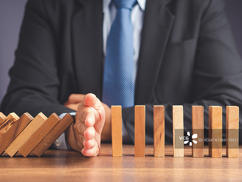 商人阻止多米诺骨牌效应导致的企业危机图片素材