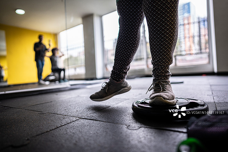 在健身房中使用踏步有氧器械锻炼的女性下半身图片素材