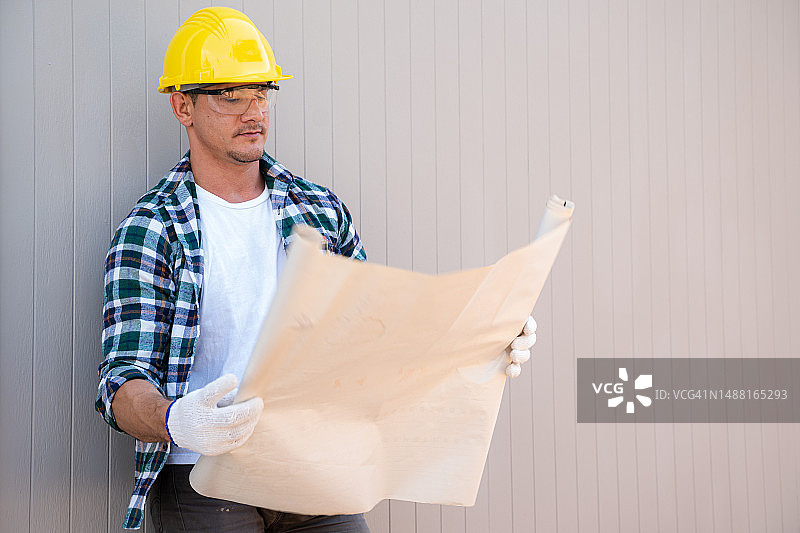 在施工现场使用蓝图工作的建筑师图片素材