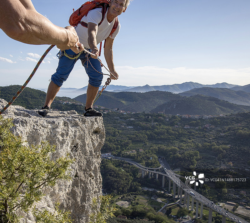 登山者沿悬崖边为向导提供保护图片素材