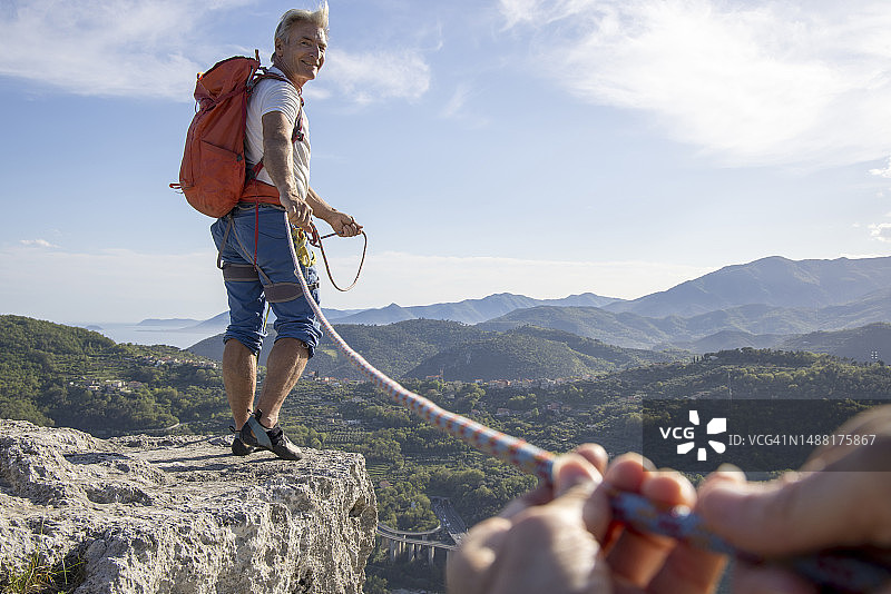 登山者沿悬崖边为向导提供保护图片素材