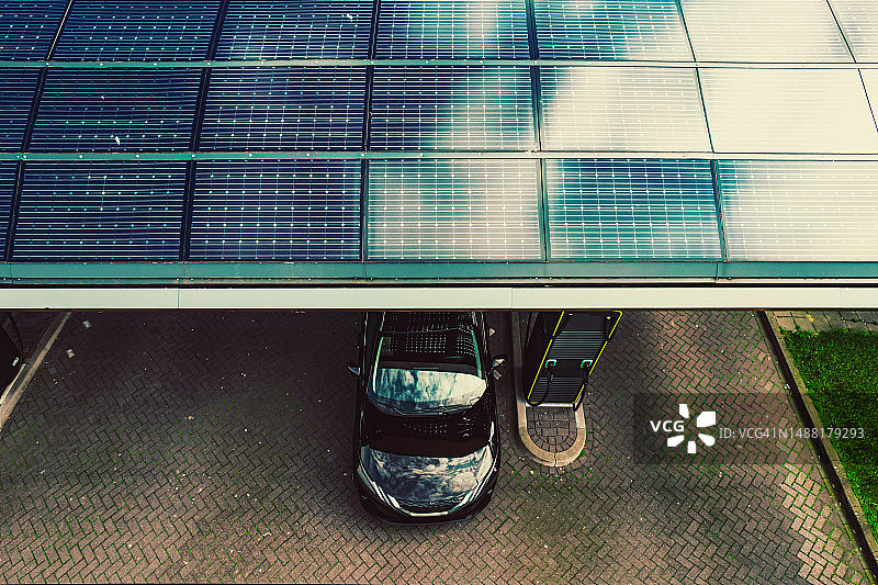 高速公路充电站的电动汽车充电桩，顶部覆盖着完整的太阳能电池板图片素材