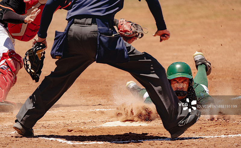 出局或安全/棒球运动员滑向本垒，对方捕手准备在比赛中接球图片素材