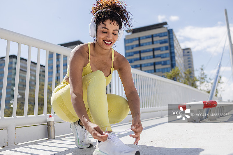 蹲下来系鞋带的年轻女人图片素材
