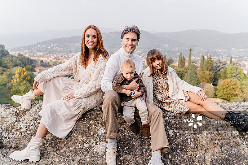 四口之家坐在大石头上图片素材