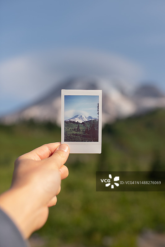 手持雷尼尔山宝丽来照片图片素材