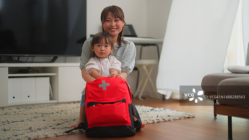 幸福的母亲和小女儿在家准备急救包的肖像图片素材