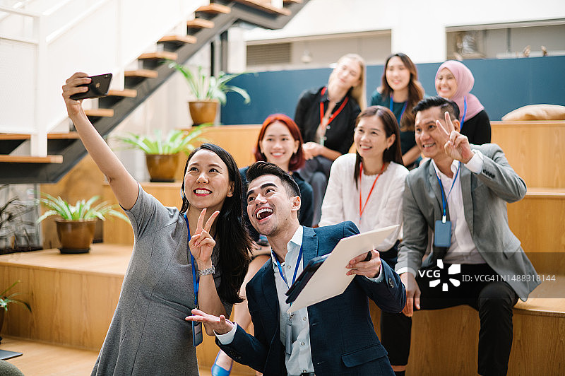 会议演讲者与参会者兴奋自拍。图片素材