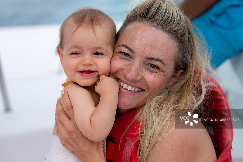 母亲在船上抱着她的女婴图片素材