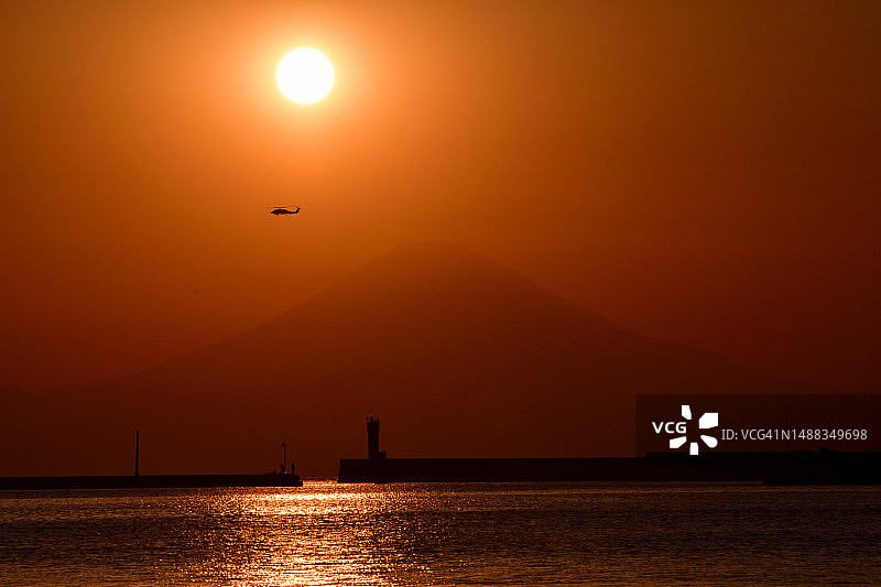从三浦半岛城岛眺望直升机飞过的富士山日落图片素材