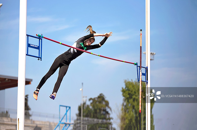 女孩撑杆跳跃过杆图片素材