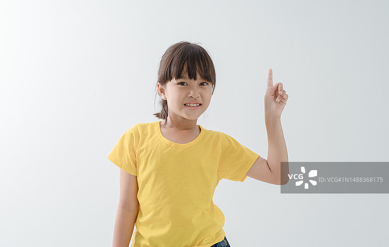 一个亚洲小孩在白色背景上摆姿势图片素材