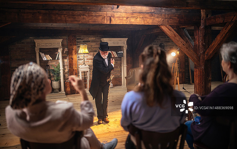 年长的男人作为演员在舞台上为观众表演图片素材