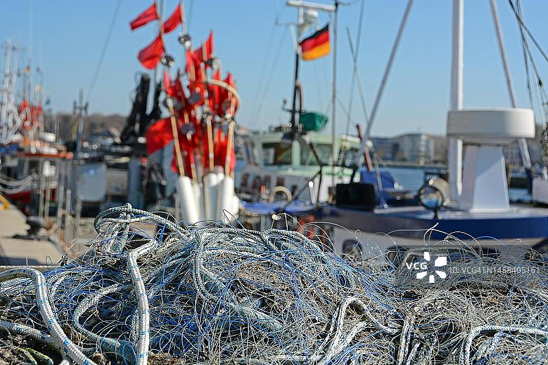 德国石勒苏益格-荷尔斯泰因州特拉弗明德渔港的渔网和渔旗图片素材