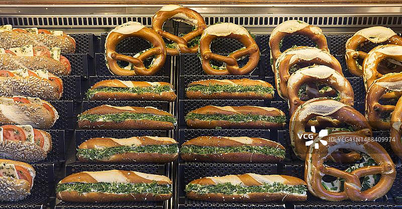 德国巴伐利亚咖啡馆展示的迷你法棍面包和椒盐卷饼图片素材