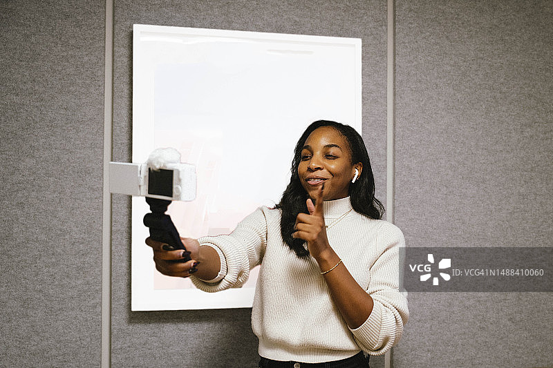 使用数码相机进行视频博客的非裔美国妇女图片素材