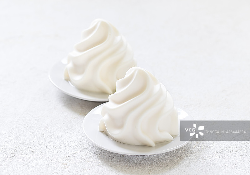 意大利甜点：香草奶油布丁，香缇奶油形式的意式奶冻，白色背景图片素材